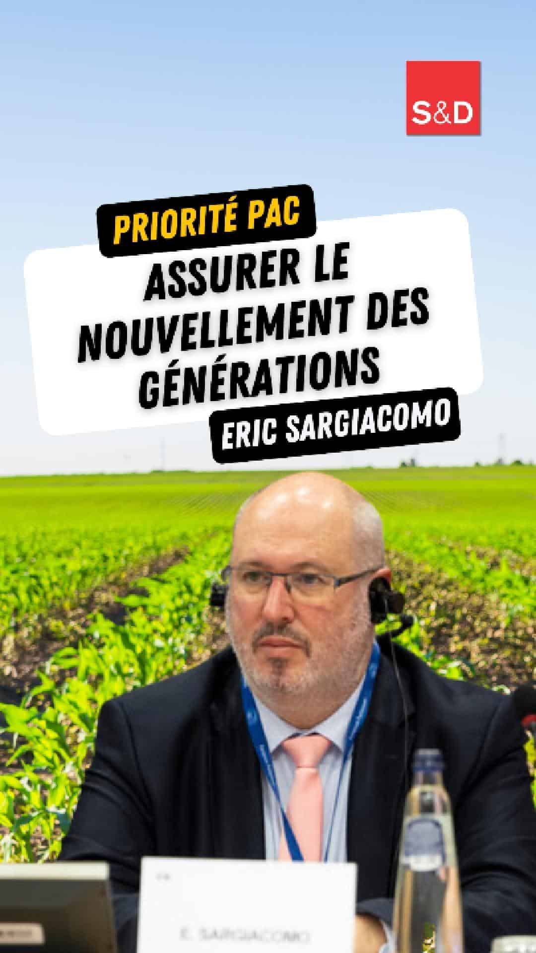 Eric Sargiacomo, député européen, lors d'un événement avec un panneau affichant "Priorité PAC : assurer le renouvellement des générations". Il porte un costume avec une cravate rose, lunettes et un casque audio, en arrière-plan un champ vert sous un ciel bleu.