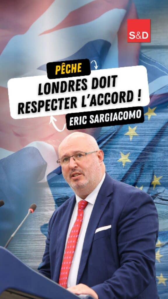1. Eric Sargiacomo, député européen, lors d'un discours public avec un panneau "Pêche Londres doit respecter l'accord" en arrière-plan.