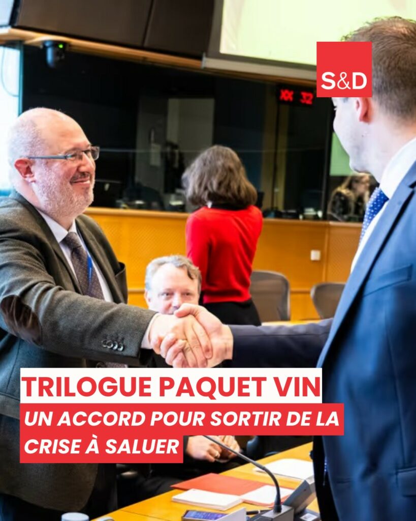 1. Portrait d'un homme politique européen serrant la main d'un autre lors d'une réunion officielle, avec des collègues en arrière-plan, dans une salle de conférence moderne.