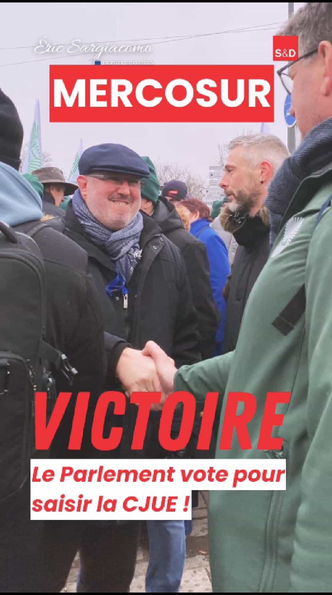 Député européen Eric Sargiacomo saluant lors d'une manifestation en faveur de la CJUE, entouré de participants, en tenue hivernale, sous ciel gris, lors d'une action pour la justice européenne.